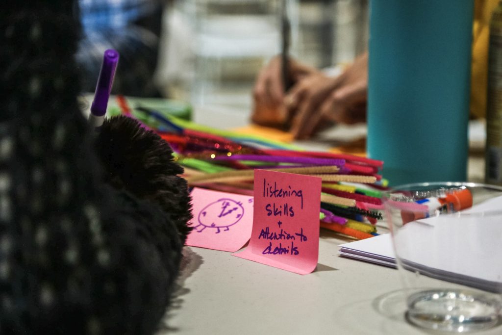 A woman writing on Post-It Notes with a purple marker.