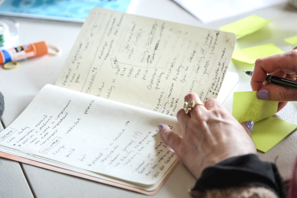 A close-up of a woman writing in a notebook.