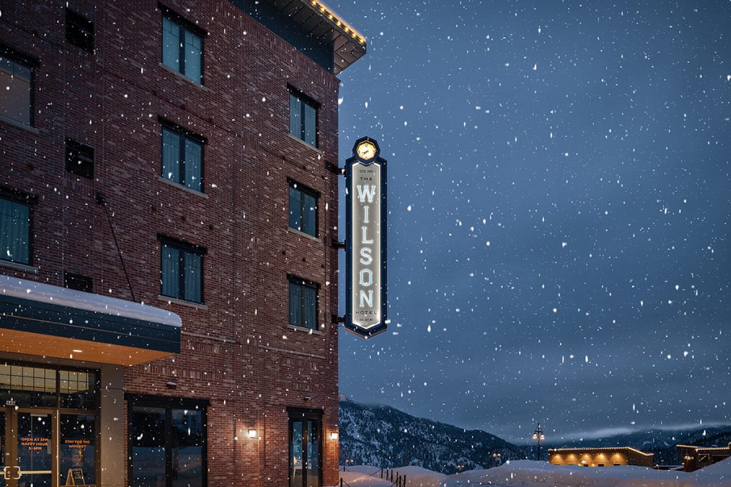 Environmental signage of the Wilson Hotel in Big Sky, Montana on a snowy night.